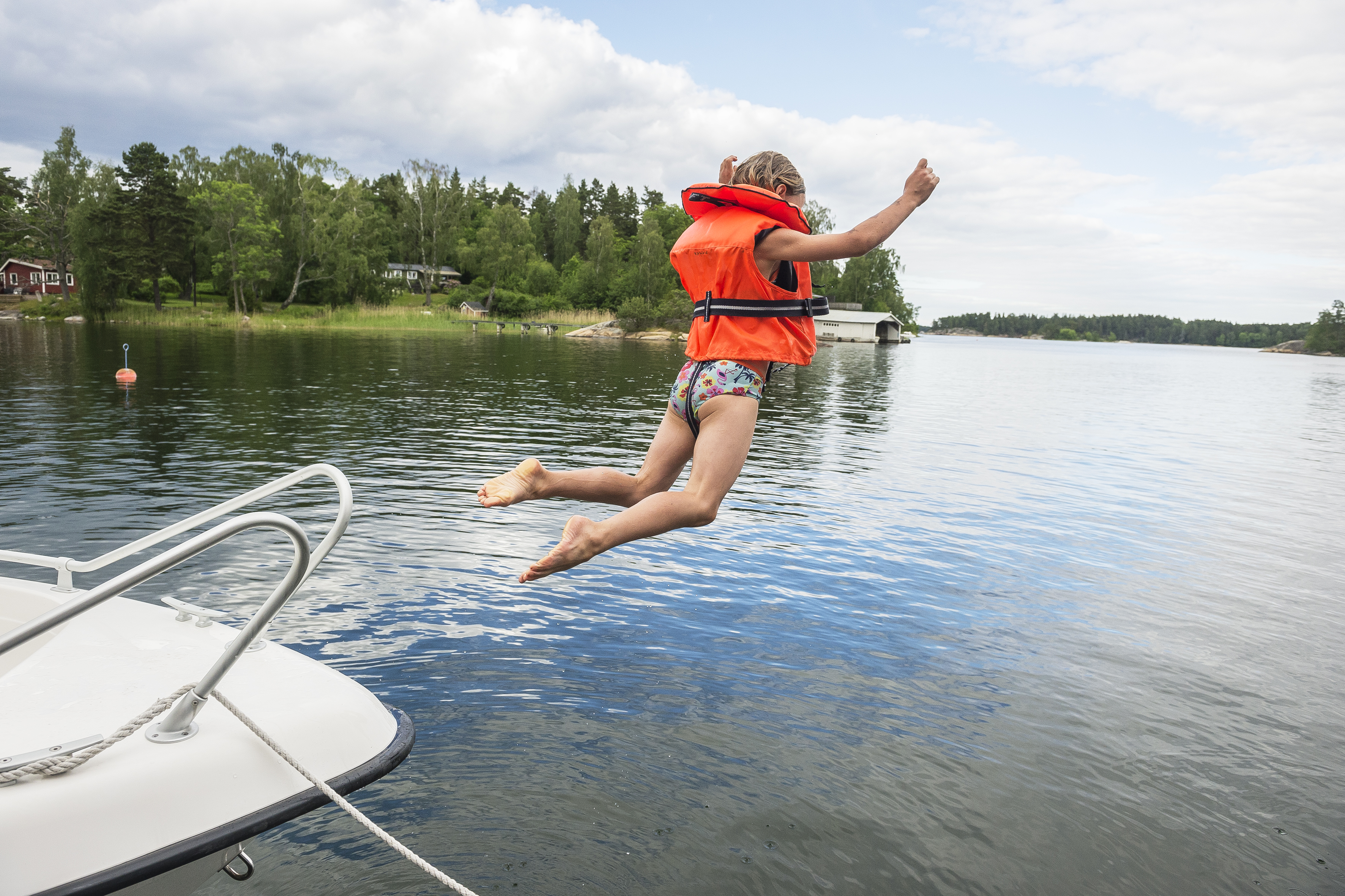 barn i flytväst hoppar från båt.jpg